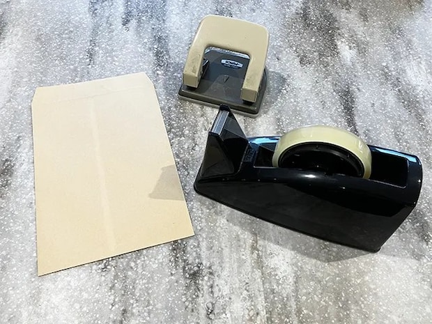 封筒、穴開けパンチ、セロハンテープを並べた場面（撮影：grapeライフハック編集部）