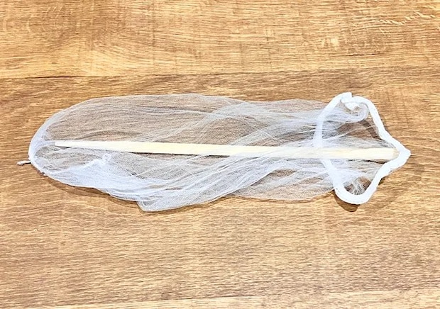 水切りネットの中に割り箸を入れて、机に置いた場面（撮影：grape編集部）