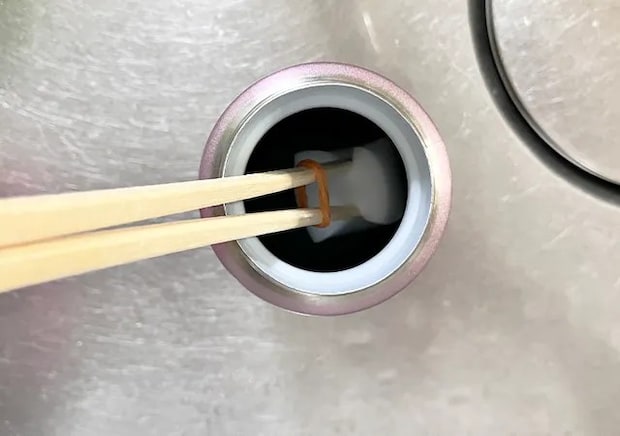 割り箸、輪ゴム、スポンジを合体させたアイテムで水筒を洗う場面（撮影：grape編集部）