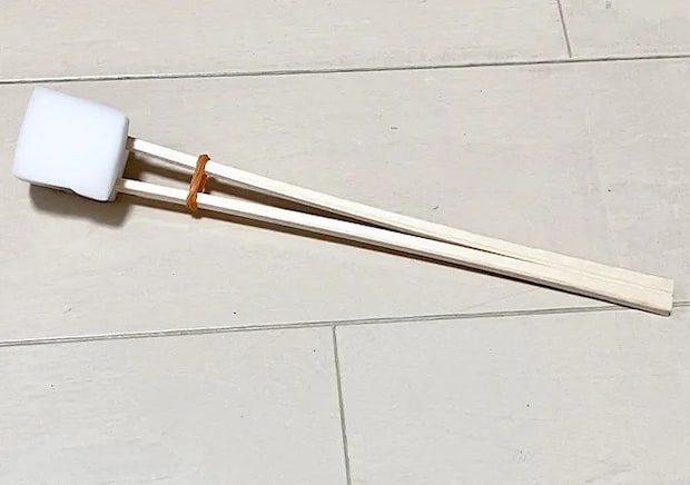 割り箸、輪ゴム、スポンジを合体させたものを床に置いた場面（撮影：grape編集部）