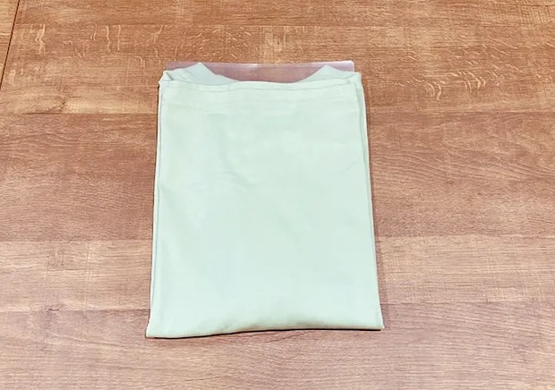 クリアファイルを土台にTシャツをたたみ、さらにクリアファイルに入れた場面（撮影：grapeライフハック編集部）