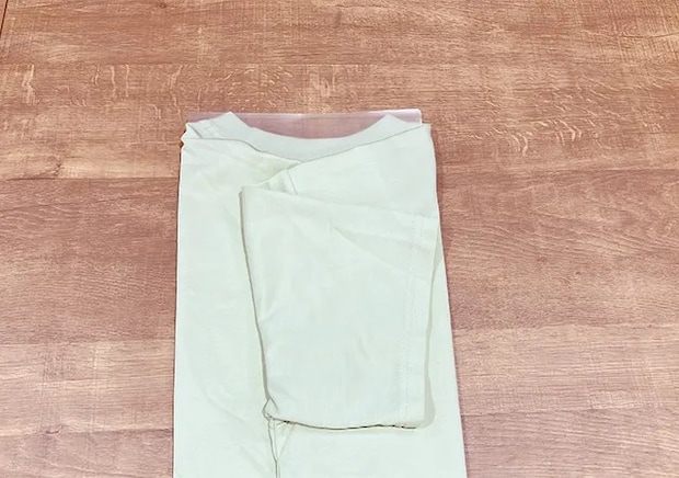 Tシャツの上にクリアファイルを置き、袖を折った場面（撮影：grapeライフハック編集部）