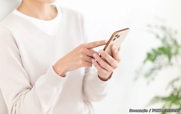 スマホを見る人の写真