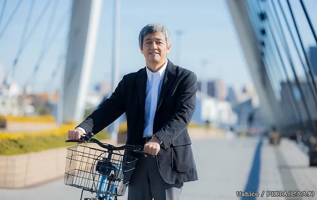 自転車を押して歩く男性の写真