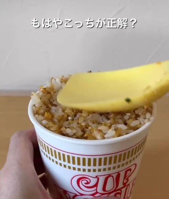 炒めたチャーハンをカップヌードルの容器に詰めている様子