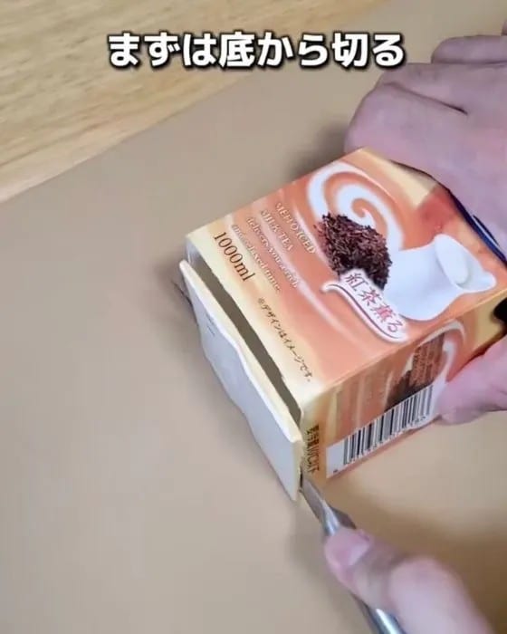 牛乳パックの底に包丁を入れている様子
