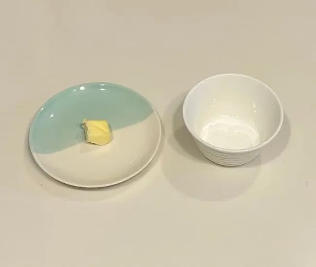 お皿にのせたバターと小さめのカップ（撮影：grapeフード編集部）