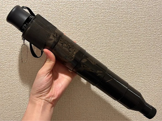 『伸縮傘カバー』に折りたたみ傘を入れている画像（撮影：grapeライフハック編集部）