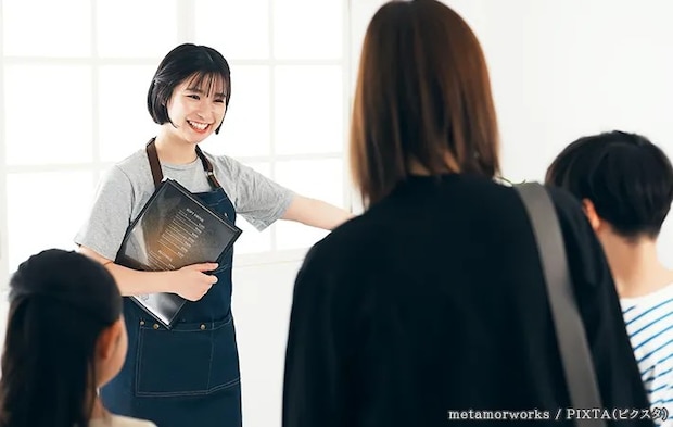 飲食店で席を案内する女性の写真