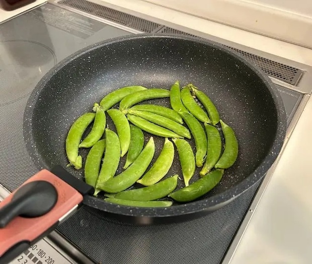 フライパンにスナップエンドウを並べている様子（撮影：grapeフード編集部）