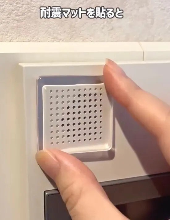 インターホンのスピーカー部分に耐震マットを貼っている様子