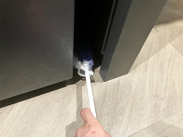 水切りネットを被せたモップで隙間を掃除する場面(撮影:grapeライフハック編集部)