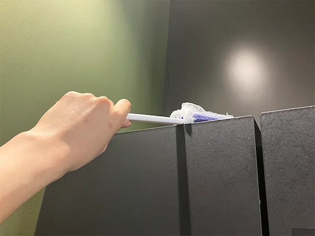 水切りネットを被せたモップで冷蔵庫上を掃除する場面（撮影：grapeライフハック編集部）