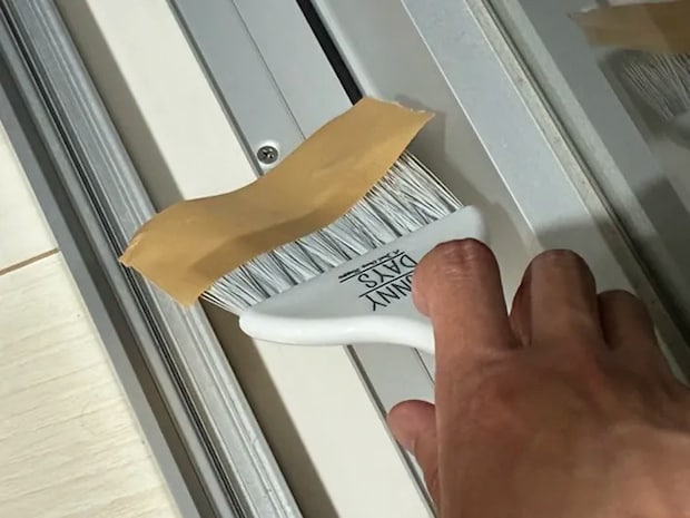 ミニほうきでサッシを掃除する場面の写真（撮影：grapeライフハック編集部）
