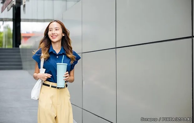 タンブラーを持つ女性の写真