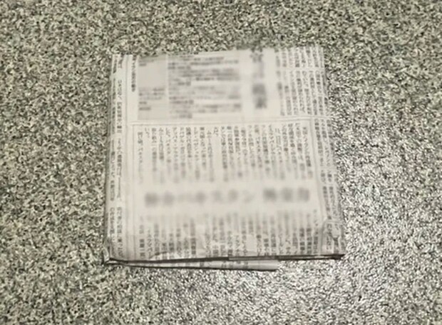 本を新聞紙で包む写真（撮影：grapeライフハック編集部）