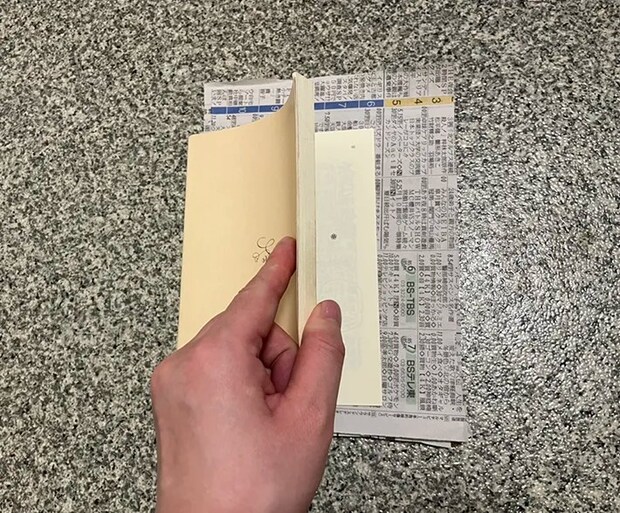 新聞紙を本に挟む写真（撮影：grapeライフハック編集部）