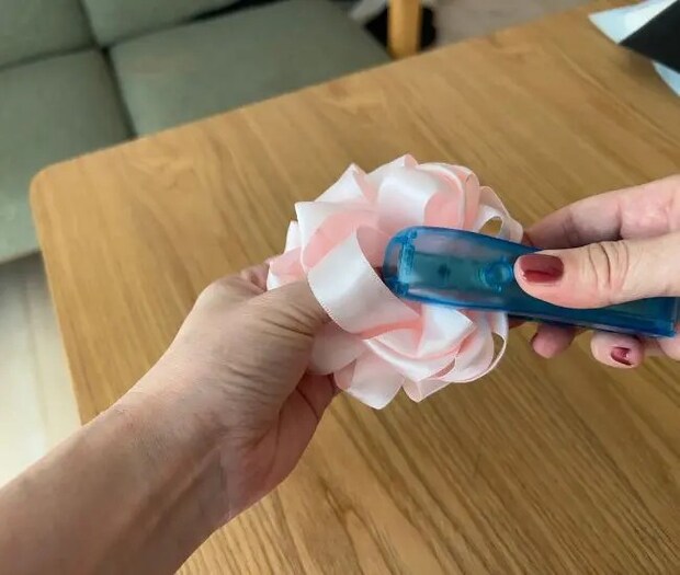 リボンの中心をホッチキスで留めている様子（撮影：grapeライフハック編集部）
