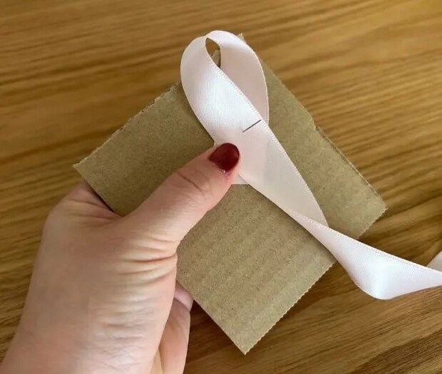 リボンを折り返してまち針に通している様子（撮影：grapeライフハック編集部）