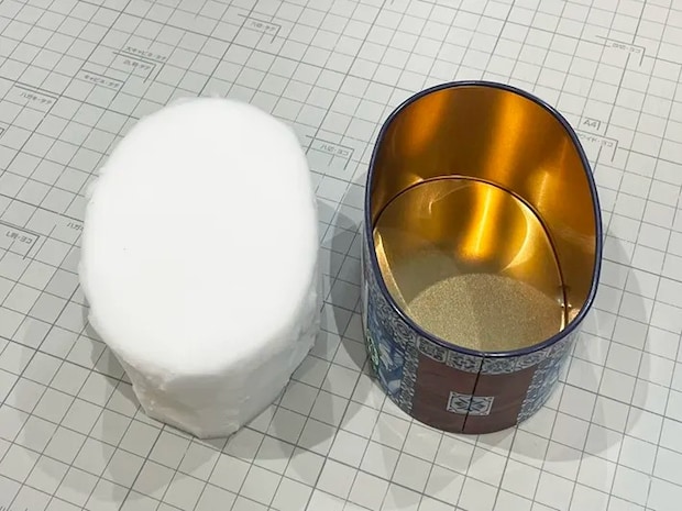 お菓子缶の形に合わせてメラミンスポンジを切った写真（撮影：grapeライフハック編集部）