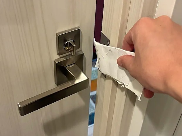 破ったトイレットペーパーの芯でドアを開けた場面（撮影：grapeライフハック編集部）