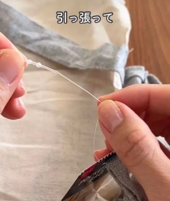 紐の先端を引っ張る様子