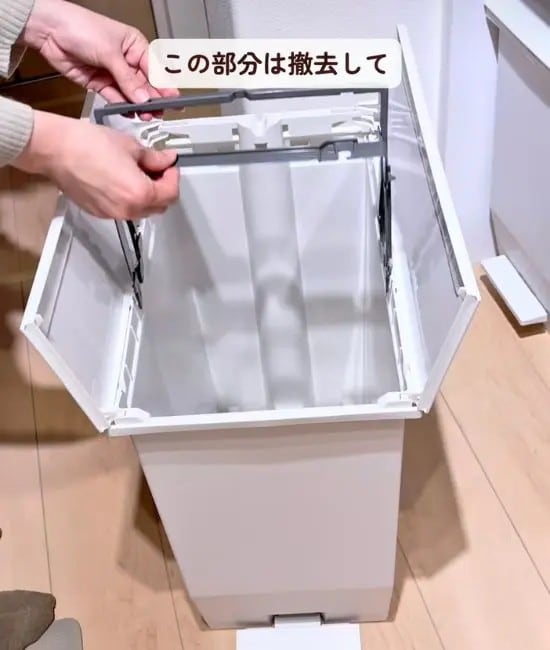 袋を固定するバーを取り外している様子