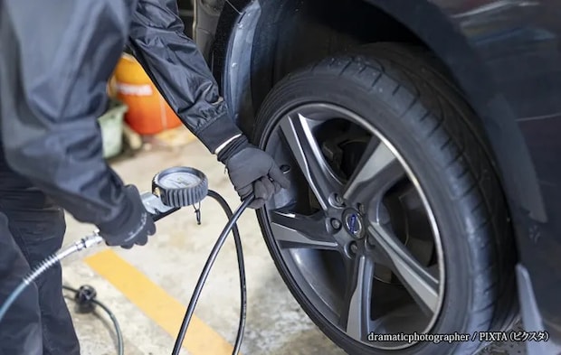 『タイヤ交換・組み換えする整備士』の写真