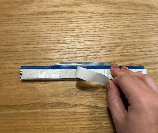 ジッパー部分をお菓子の袋に貼りつける様子（撮影：grapeフード編集部）