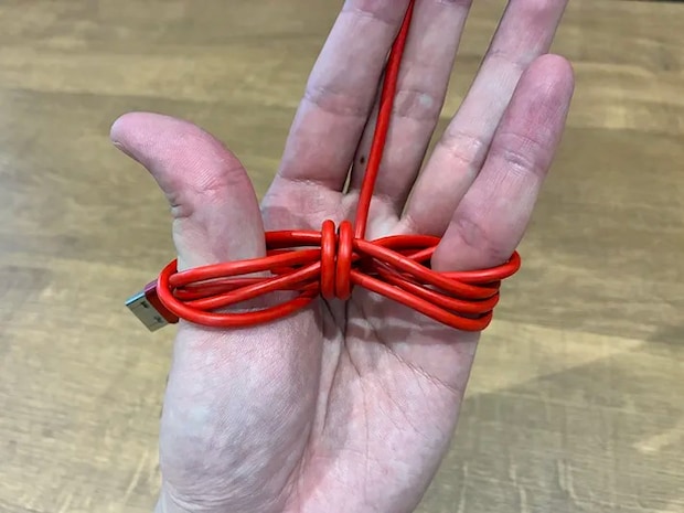 親指と小指に巻いた充電ケーブル（撮影：grapeライフハック編集部）