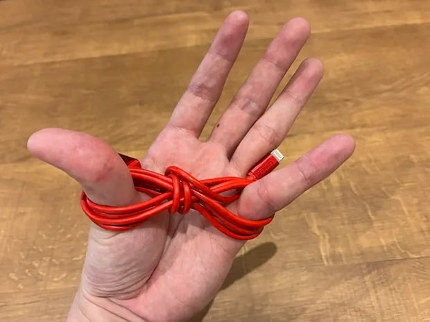 親指と小指に巻いた充電ケーブル（撮影：grapeライフハック編集部）
