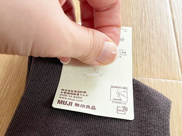 無印良品の靴下のタグ糸を持つ写真（撮影：grapeライフハック編集部）