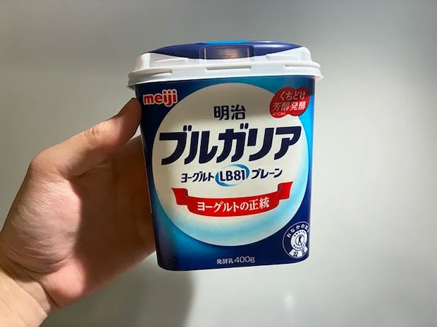手で持った明治ブルガリアヨーグルトの空き容器（撮影：grapeライフハック編集部）