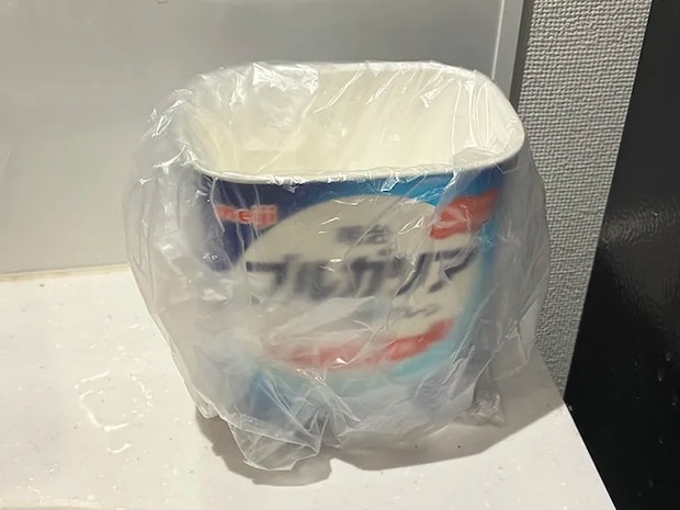 ビニール袋をかぶせた明治ブルガリアヨーグルトの空き容器（撮影：grapeライフハック編集部）