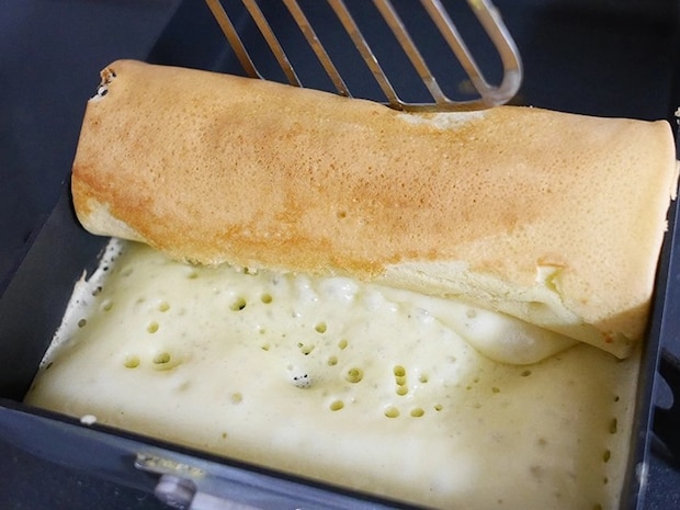 卵焼き器で生地を巻いていく（撮影：grapeフード編集部）