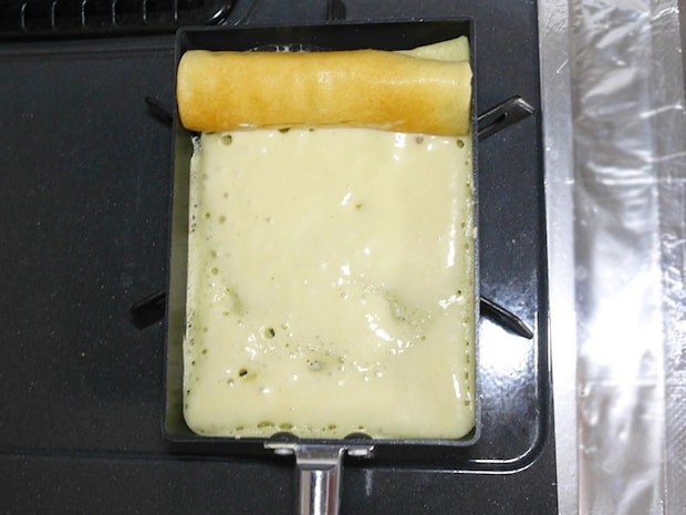 卵焼き器で生地を巻いていく（撮影：grapeフード編集部）