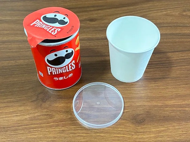 机に置かれたプリングルズの容器と、紙コップ（撮影：grapeライフハック編集部）