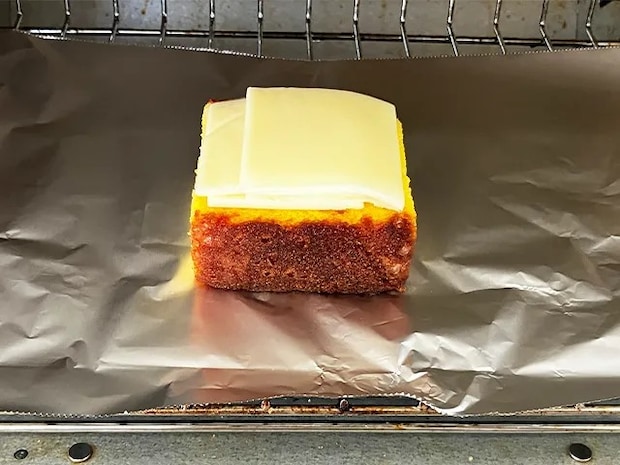カステラの上にとろけるチーズをのせ、トースターに入れた場面（撮影：grapeフード編集部）