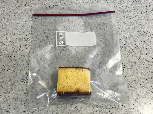 ラップに巻いたカステラをジッパー付き袋に入れた場面（撮影：grapeフード編集部）
