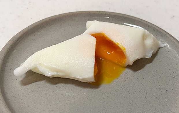 コーヒーフィルターで作ったポーチドエッグを割って中身を見せている写真
