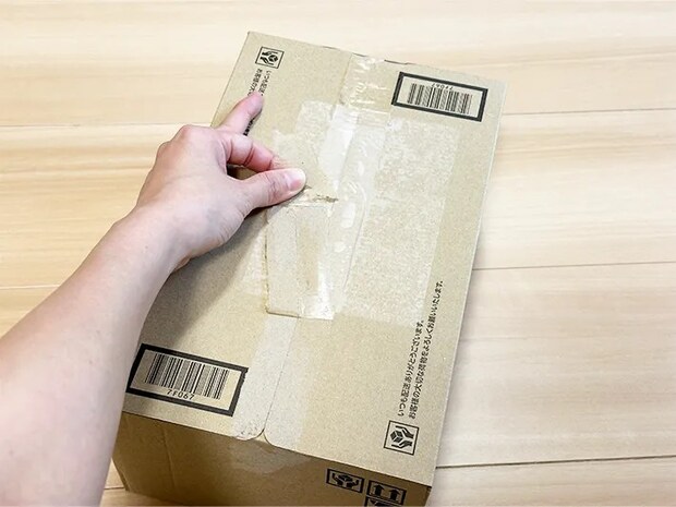テープを剥がしてダンボールを開封している画像（撮影：grapeライフハック編集部）