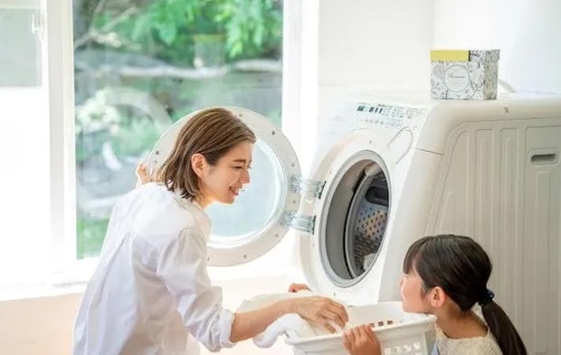 『洗濯機から衣類を出す女性と子供』（撮影：Heulie）写真