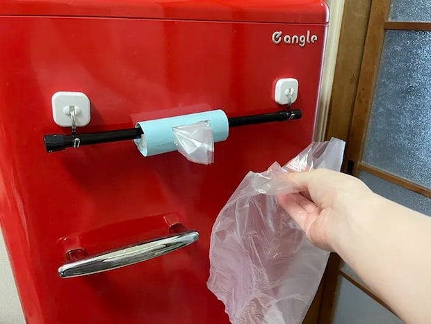 冷蔵庫にトイレットペーパーの芯で作ったビニール袋の収納を取り付けた写真（撮影：grapeライフハック編集部）