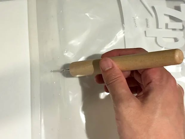 ジッパー袋にキリで穴を開ける場面（撮影：grapeライフハック編集部）