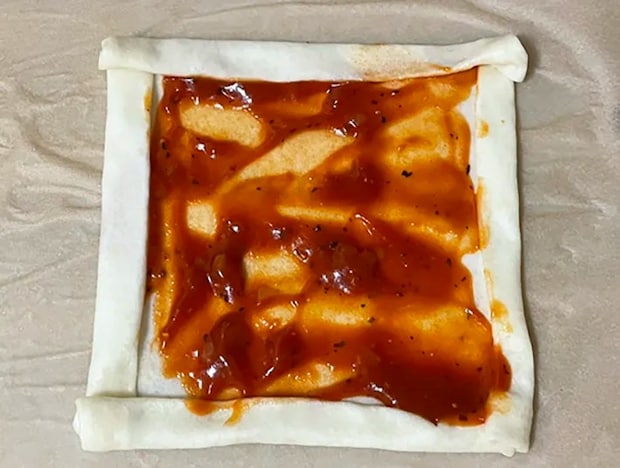 春巻きの皮にピザソースをかける写真（撮影：grapeフード編集部）