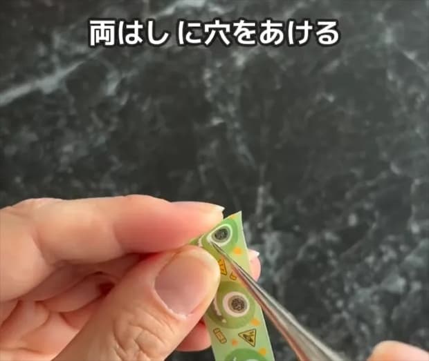 マスキングテープを貼ったクリアファイルに穴を開ける画像
