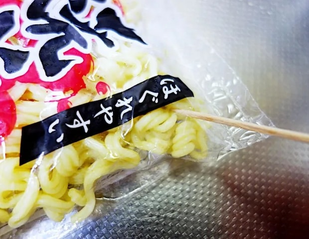 焼きそばの袋に穴を開ける画像（撮影：エニママ）