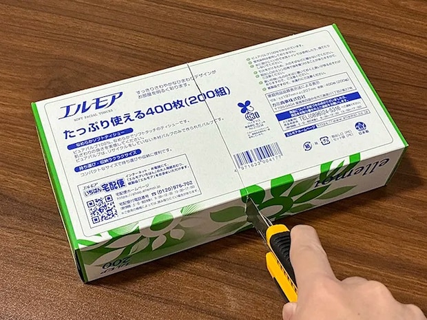 カッターで空き箱に一直線の切れ込みを入れる場面（撮影：grapeライフハック編集部）