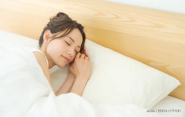 『ベッドで寝る女性』の写真