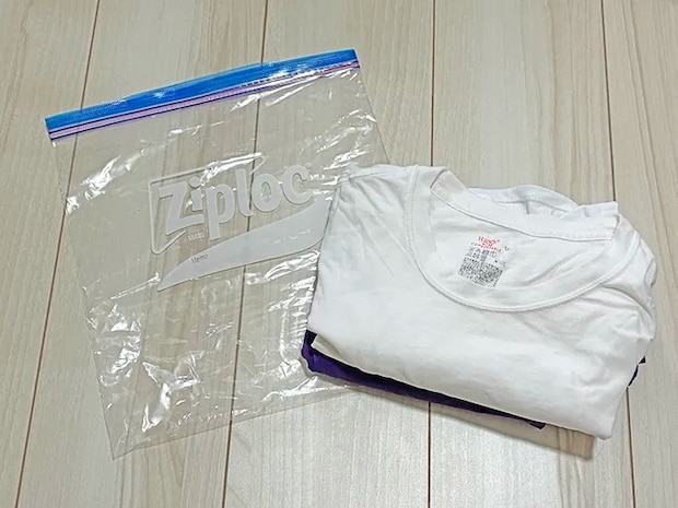 床に置かれたジッパー袋とTシャツ、半ズボン（撮影：grapeライフハック編集部）